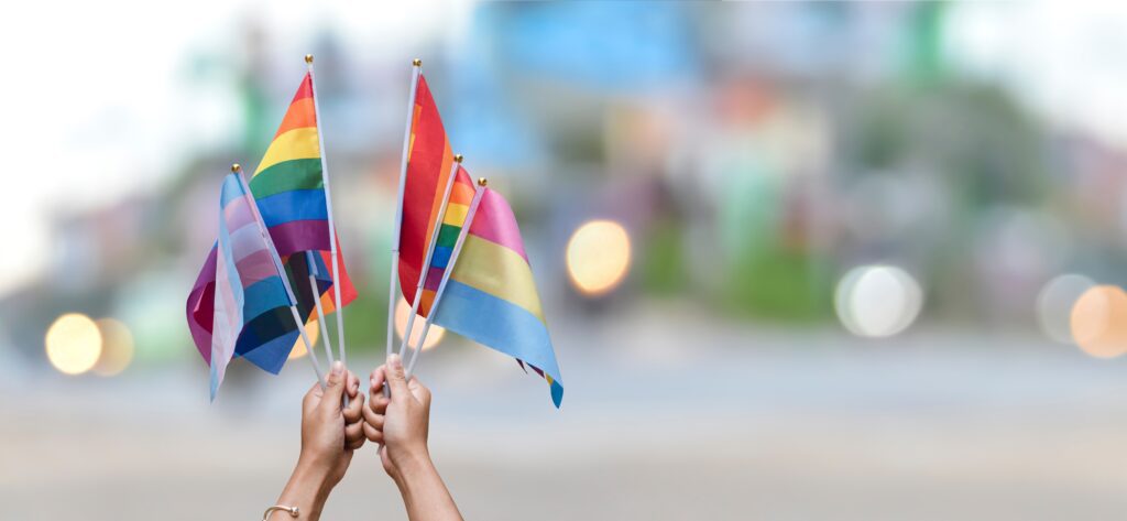 Hands holding rainbow flags