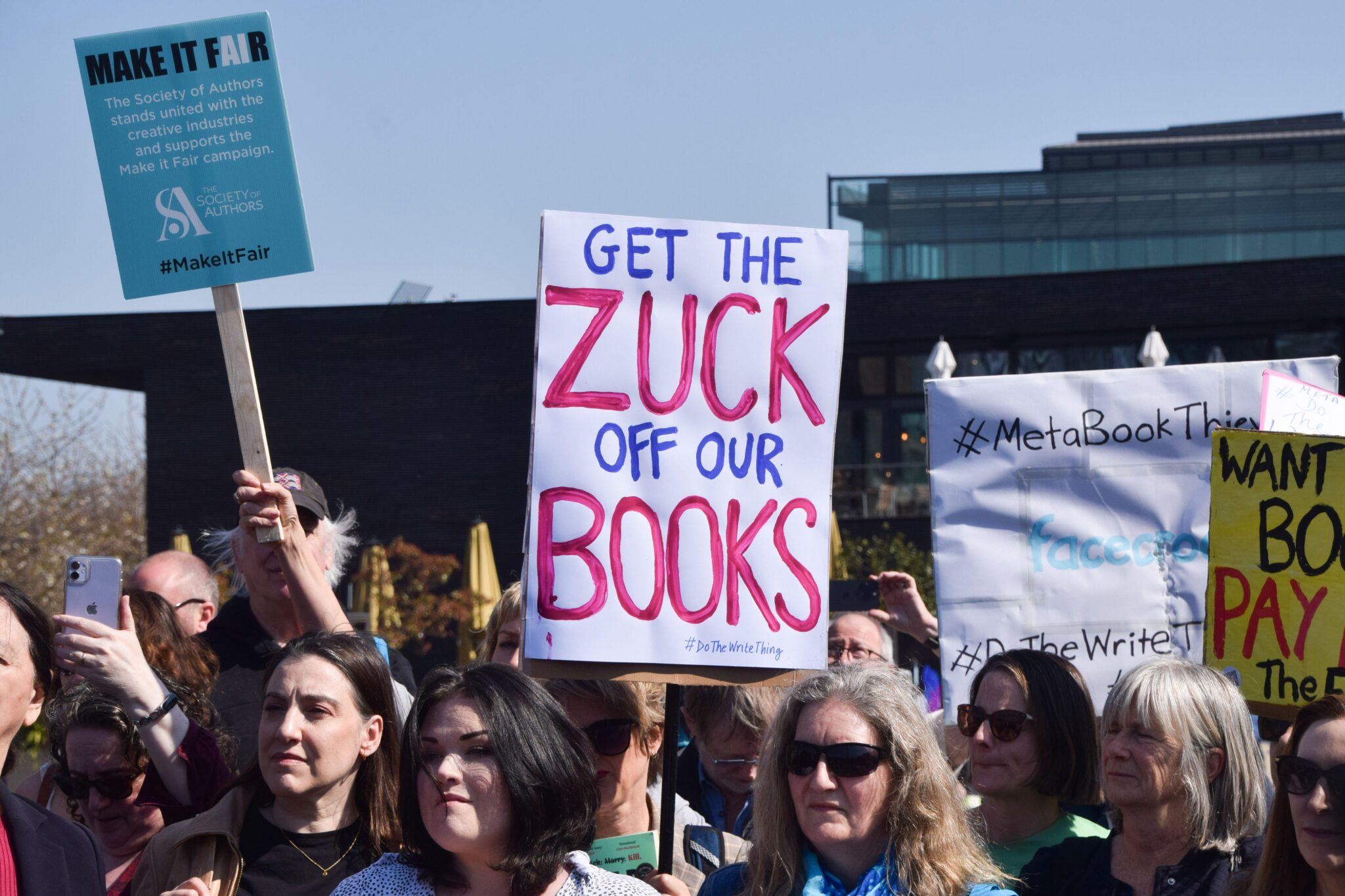 Authors outside of Meta offices with placard that says 'Get the Zuck off our books'